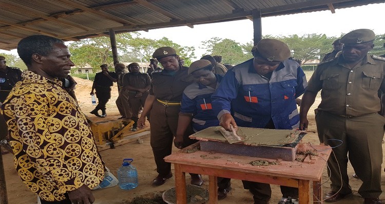Askari wa Jeshi la Magereza wakiwa katika majaribio ya kutengeneza vigae mkonge wakati wa mafunzo ya ujenzi wa nyumba bora za gharama nafuu iliyotolewa na NHBRA 